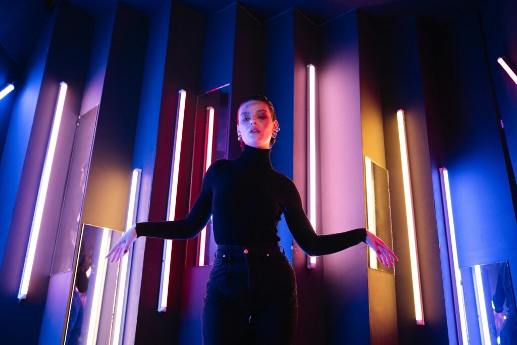 Woman in stylish turtleneck with neon lights in modern artistic setting.